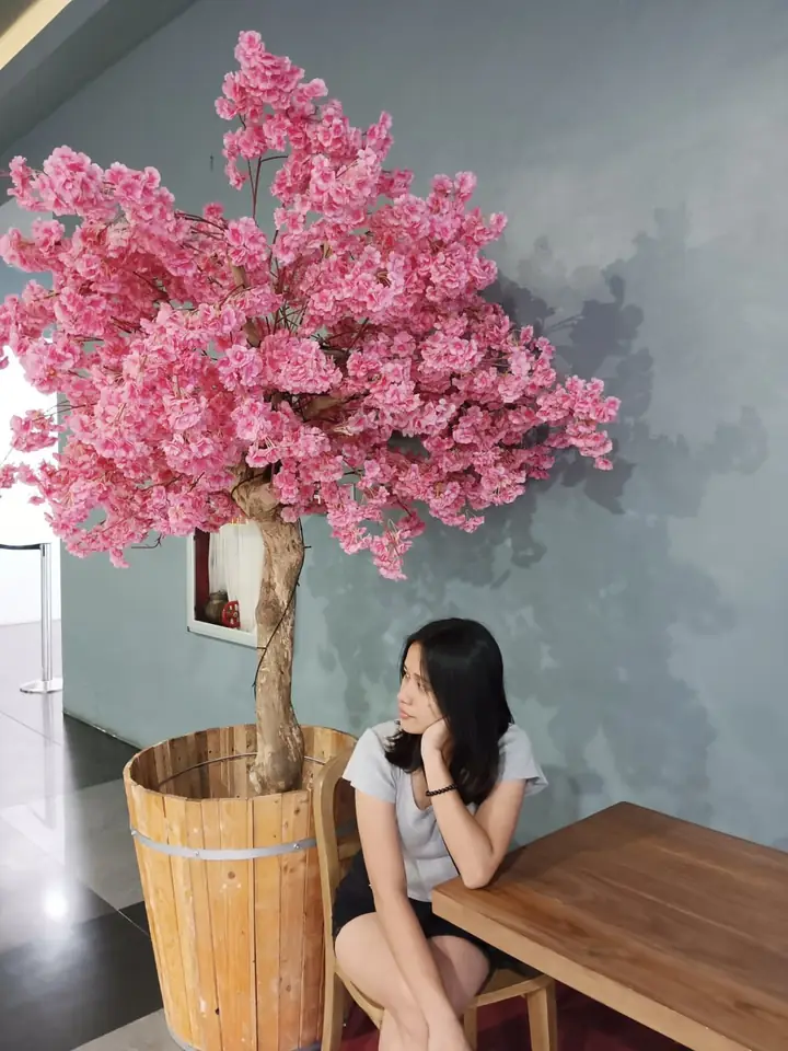 Mariella beside a pink flower tree